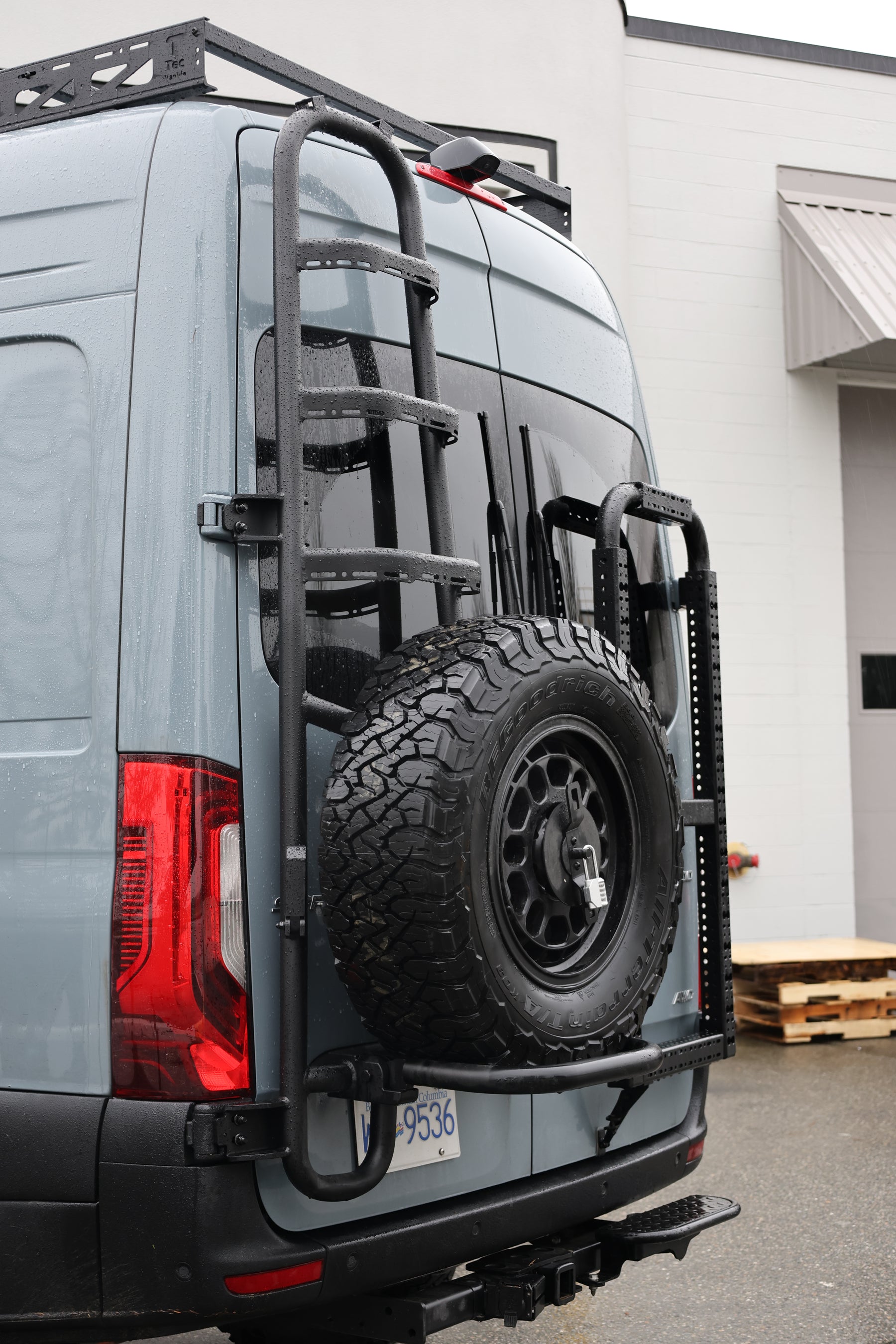 Tec Vanlife Sprinter tire ladder carrier viewed from the rear with spare tire mounted
